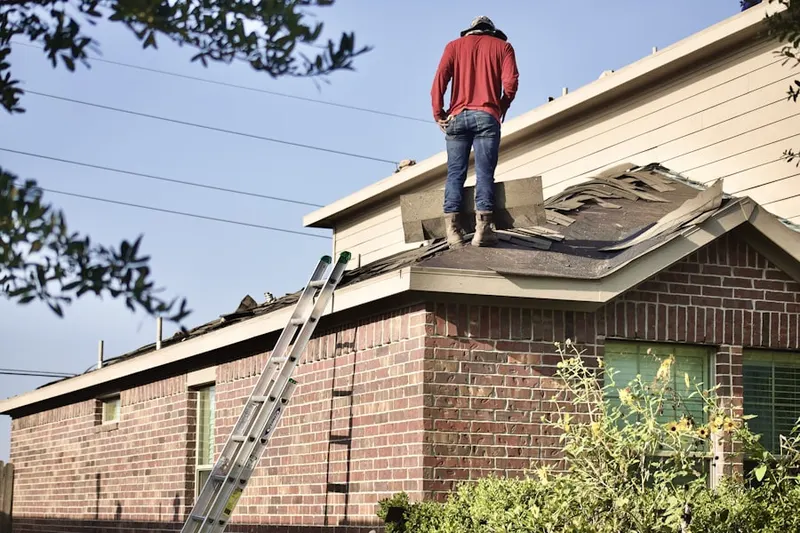 Professional roofer working on a residential roof in Highland Woods